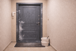 fotografie cu o usa de apartament gri antracit murdara de resturi dupa renovarea apartamentului